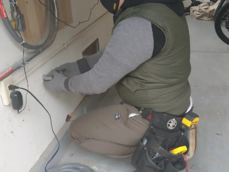 Electrician performing outlet wiring in a Algoma garage